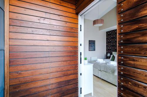 een houten schuifdeur in een kamer met een bed bij Tranquil 3 Bedroom Manchester Retreat With Parking in Manchester