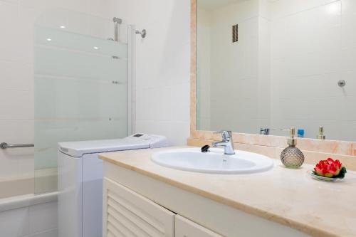 Un baño blanco con lavabo y ducha. en Modern apartment in Golf del Sur, AC237, tempered pool and ocean view, en San Miguel de Abona