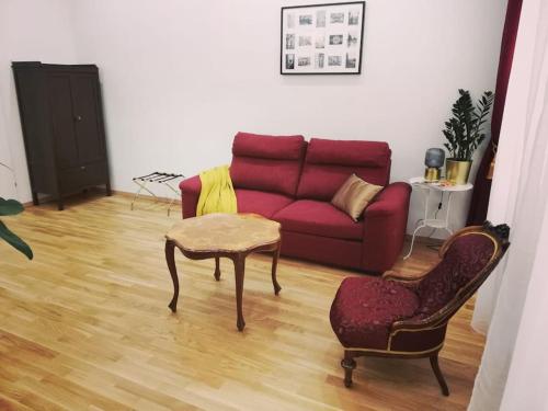ein Wohnzimmer mit einem roten Sofa und einem Stuhl in der Unterkunft Heart street with a piece of old Vienna style in Wien