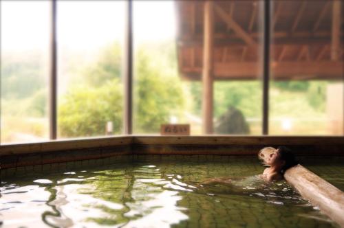 a young child swimming in a swimming pool at Sannouzan Onsen Zuisenkyo in Ichinoseki