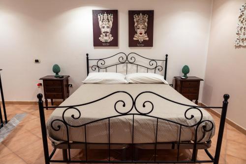 een slaapkamer met een zwart bed met twee foto's aan de muur bij Daria’s home apartament in Palermo