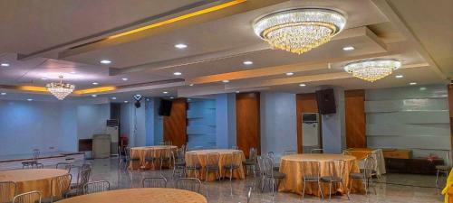 un salón de banquetes con mesas, sillas y lámparas de araña en PHELA GRANDE HOTEL en General Santos