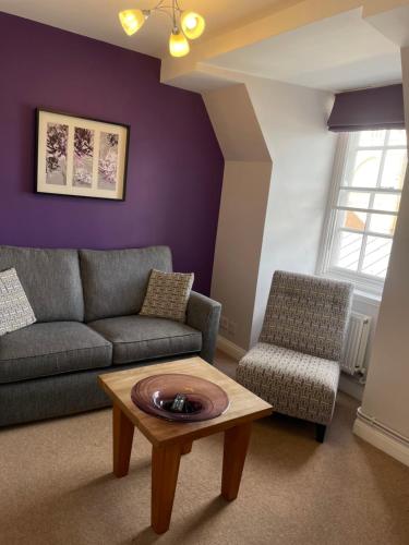 a living room with a couch and a table at Canterbury Cathedral Lodge in Canterbury