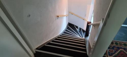 a stairway with a black and white staircase at Edel Apartments Dulliken in Dulliken