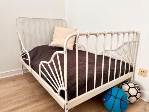 a white crib in a room with a soccer ball at Modernes Appartement Nähe City in Dortmund