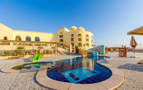 un complexe avec une piscine en face d'un bâtiment dans l'établissement Siva Golden Bay Makadi, à Hurghada