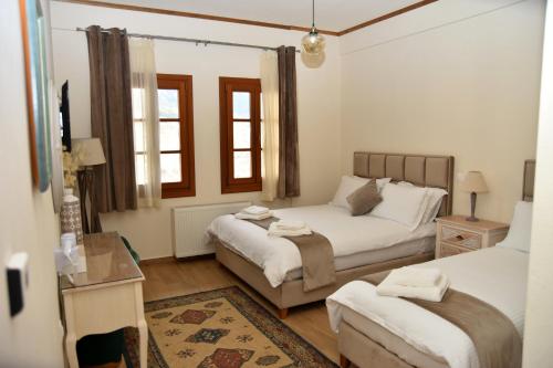 メツォヴォにあるNUCA GUESTHOUSEのベッドルーム1室(ベッド2台、テーブル付)
