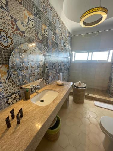 La salle de bains est pourvue d'un lavabo et de toilettes. dans l'établissement Villa La Falaise, à Oualidia