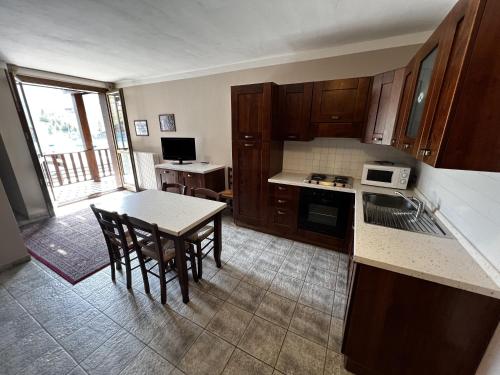 a kitchen with wooden cabinets and a table and chairs at Chalet Edelweiss - Estella Hotel Collection in Sestriere