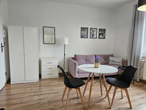 a living room with a table and chairs and a couch at Apartamenty HARDOM in Opole