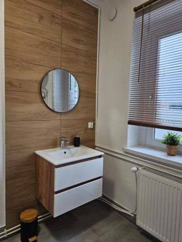 a bathroom with a white sink and a mirror at Apartamenty HARDOM in Opole
