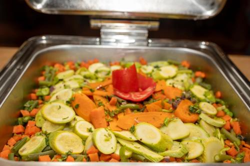 a pan filled with carrots and cucumbers and vegetables at Siva Golden Bay Makadi in Hurghada