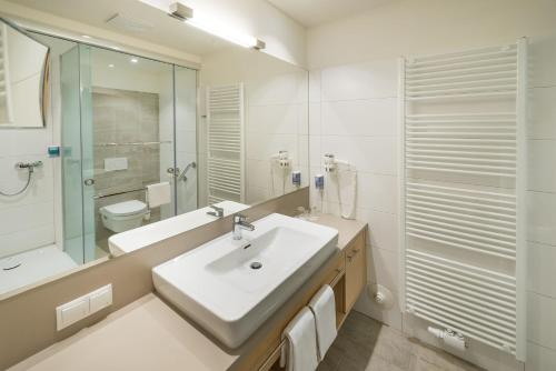 a bathroom with a sink and a shower and a toilet at Wilfinger Ring Bio Hotel in Hartberg