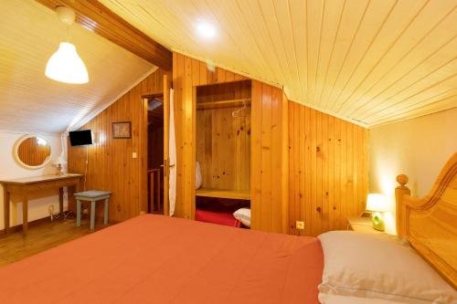 een slaapkamer met een bed in een kamer met houten wanden bij Casa Azenha Branca in Esposende