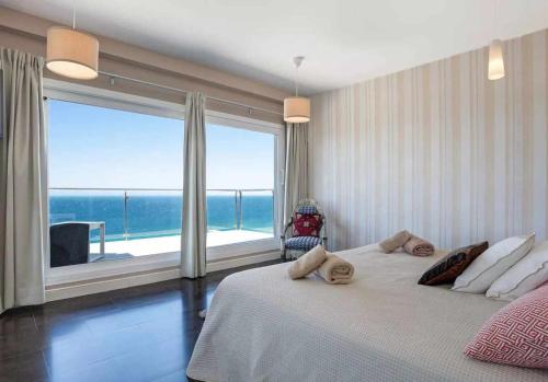 a bedroom with a large bed with a large window at LUJOSA VILLA PISCINA 25 METROS SUIT 60m2 SPA SAUNA in Zahara de los Atunes