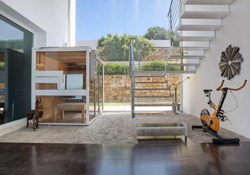 a living room with a staircase and a scooter at LUJOSA VILLA PISCINA 25 METROS SUIT 60m2 SPA SAUNA in Zahara de los Atunes