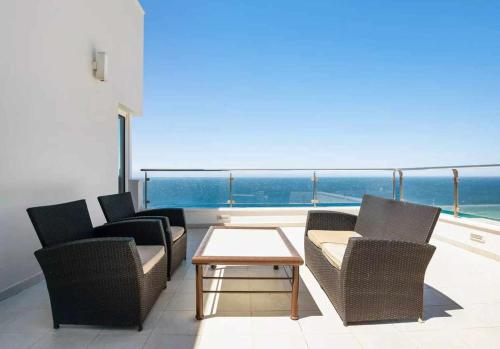 a balcony with chairs and a table and the ocean at LUJOSA VILLA PISCINA 25 METROS SUIT 60m2 SPA SAUNA in Zahara de los Atunes
