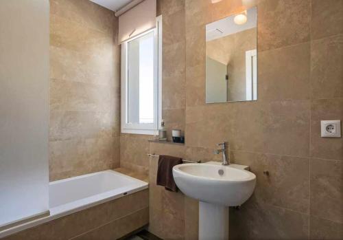 a bathroom with a sink and a tub and a mirror at LUJOSA VILLA PISCINA 25 METROS SUIT 60m2 SPA SAUNA in Zahara de los Atunes