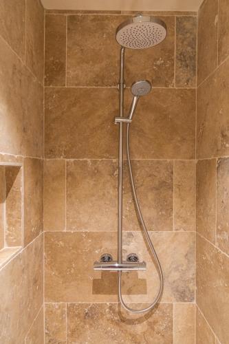 une douche avec pommeau de douche dans une salle de bain dans l'établissement residentie Gaugin C4, à Malaucène