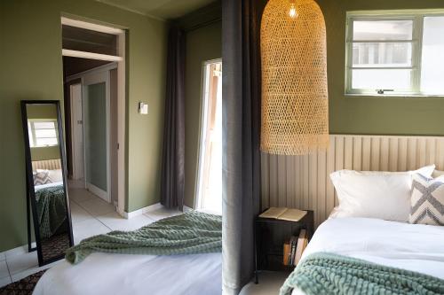1 dormitorio con cama y espejo en Seaside Stay - Beachfront/ Backup Inverter/ Housekeeping en Ballito