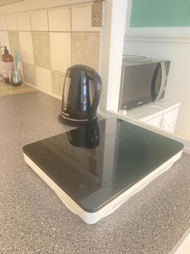 a black appliance sitting on top of a kitchen counter at En lille lejlighed i midtbyen - hyggelig, centralt og tæt på alt! in Randers