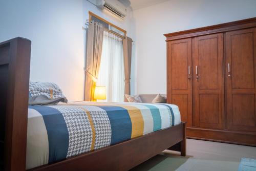 Schlafzimmer mit einem Bett und einem Holzschrank in der Unterkunft Cozy room only 20 minutes from the city center! in Ngaglik