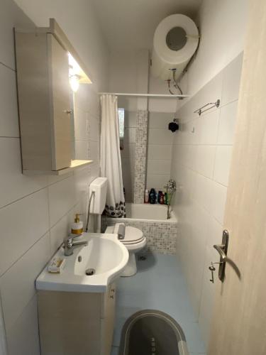 Baño blanco con lavabo y aseo en Convenient Studio, en Atenas