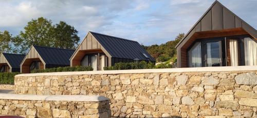 a stone wall in front of a house at The Rocks - Luxury Glamping Resort in Newry