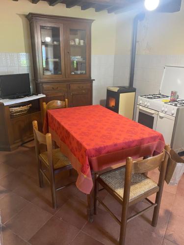 uma cozinha com uma mesa com uma toalha de mesa vermelha em Casa Faini em Sorano