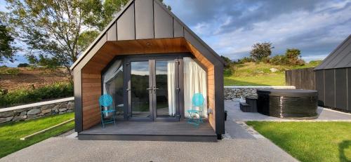 um pequeno barracão com duas cadeiras e um grelhador em The Rocks - Luxury Glamping Resort em Newry