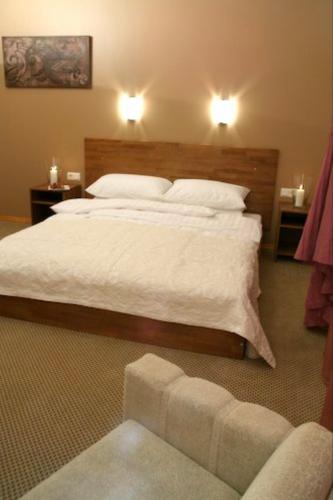 ein Schlafzimmer mit einem großen Bett mit weißer Bettwäsche in der Unterkunft Viesnīca Atpūta in Cēsis