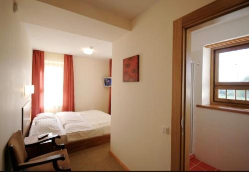 Schlafzimmer mit einem Bett, einem Schreibtisch und einem Fenster in der Unterkunft Viesnīca Atpūta in Cēsis
