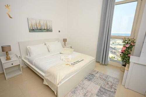 ein weißes Bett in einem Zimmer mit Fenster in der Unterkunft Mangrove Bliss - Cozy 2BR Apartment in Abu Dhabi