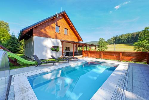 a house with a swimming pool and a house at Wellness Chalupa Horní Orlice in Králíky