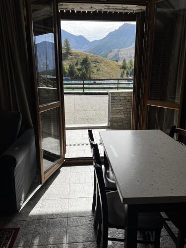 a table and chairs in a room with a large window at Chalet Edelweiss - Estella Hotel Collection in Sestriere