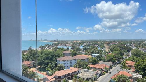 a view from a window of a city and the ocean at Luxury Apartment near airport in Negombo