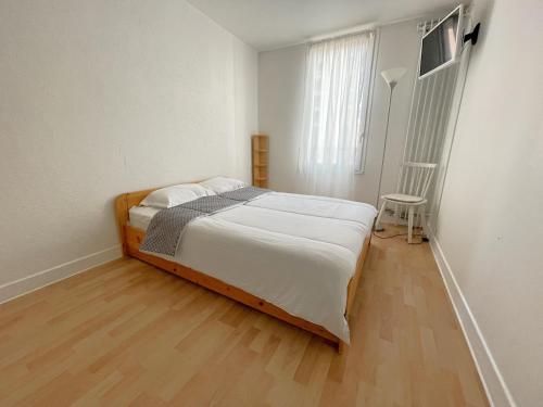 1 dormitorio con 1 cama y suelo de madera en Les Aubépines entre Disney et Paris, en Champs-Sur-Marne