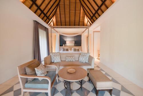a living room with a couch and a table and chairs at Ramayana Suites and Resort in Kuta