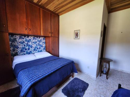 Un dormitorio con una cama y un armario de madera. en Pousada Pedacinho do Ceu suite Giulia 4, en Cunha