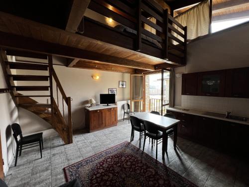 a living room with a table and chairs and a staircase at Chalet Edelweiss - Estella Hotel Collection in Sestriere