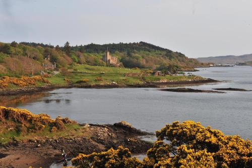 a view of a river with a castle in the distance at The Causeway in Bracadale