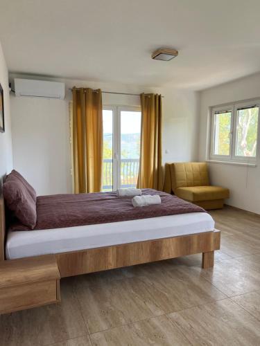 een slaapkamer met een groot bed en een balkon bij Apartmani PORTO in Golubac