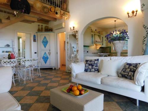a living room with a white couch and a table at Wonderful villa with swimming pool on Albarella in Palazzo Vianello