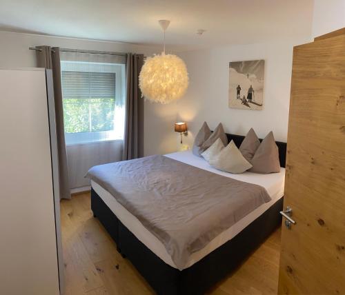 een slaapkamer met een groot bed en een kroonluchter bij Eggerbauer in Brixen im Thale