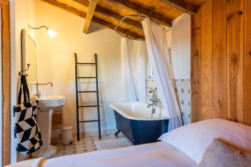 - une chambre avec un lit, un lavabo et une baignoire dans l'établissement La Villa La Dune, à Lège-Cap-Ferret