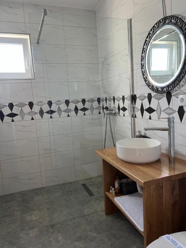 a bathroom with a sink and a mirror at Apartmani PORTO in Golubac