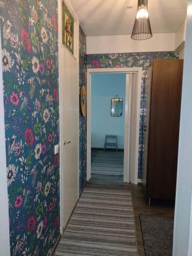 a hallway with floral wallpaper and a hallway with a door at Ihastuttava kaksio Lahdessa in Lahti