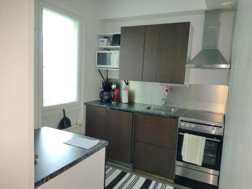 a kitchen with a sink and a stove top oven at Ihastuttava kaksio Lahdessa in Lahti