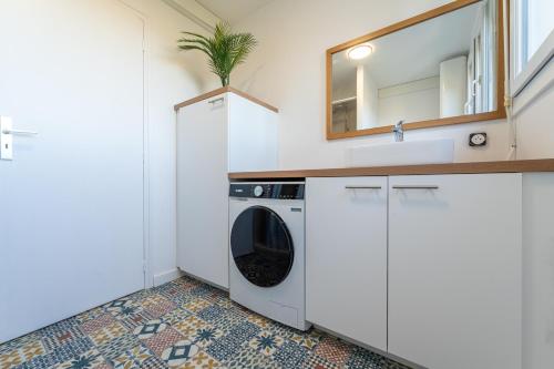 a laundry room with a washing machine and a mirror at Bordeaux - Ma Résidence Privée in Bègles