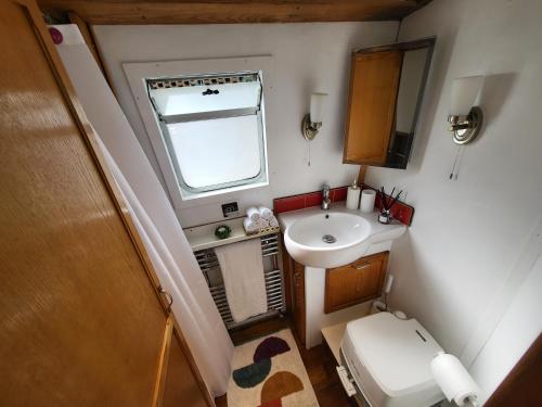 Baño pequeño con lavabo y aseo en Cosy Canal Boat in London Centre for Family & Friends, en Londres